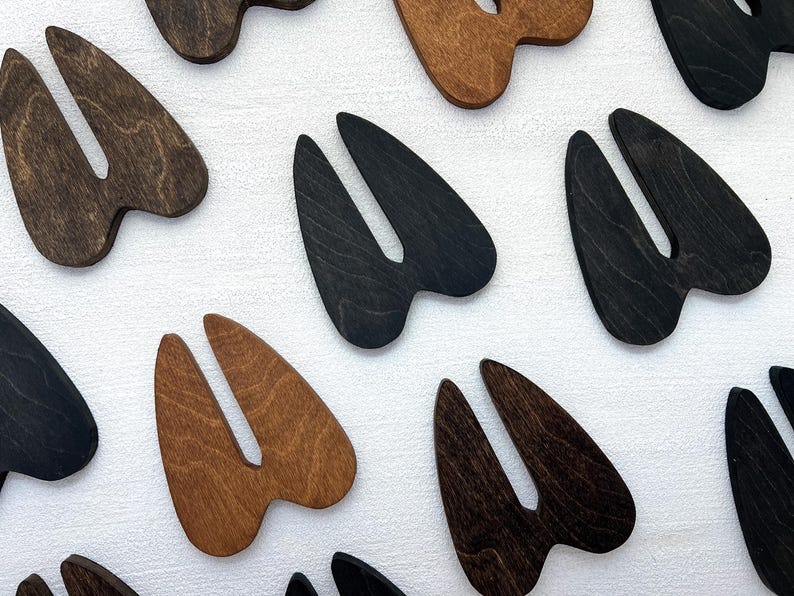 K&ouml;nnte beinhalten: Ein Satz von acht Holz-Tierhufabdr&uuml;cken in zwei Farben: Braun und Schwarz. Die Abdr&uuml;cke sind in Form eines gespaltenen Hufs mit zwei Zehen.