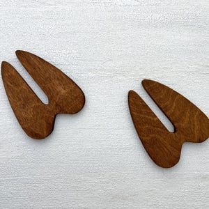 K&ouml;nnte beinhalten: Zwei Holz-Ausschnitte von einem Hirschabdr&uuml;cken. Die Hirschabdr&uuml;cke sind braun und haben eine nat&uuml;rliche Holzmaserung.