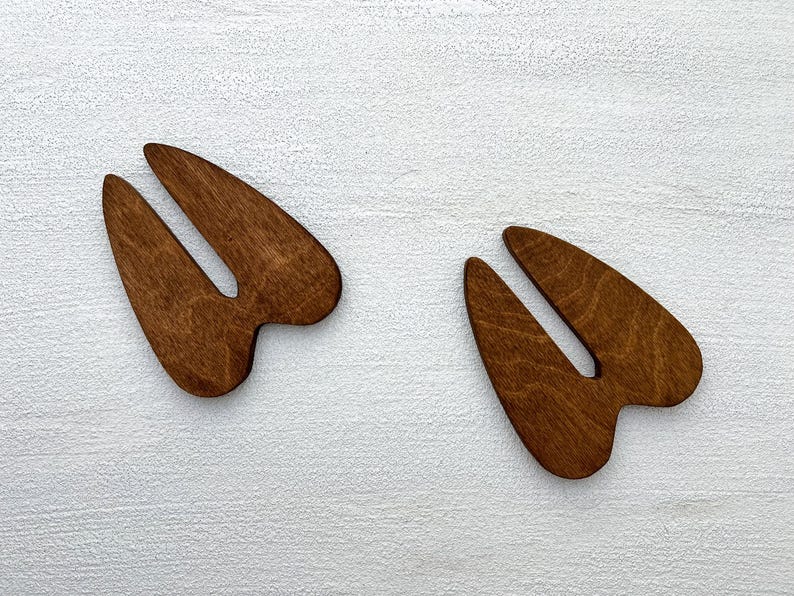 K&ouml;nnte beinhalten: Zwei Holz-Ausschnitte von einem Hirschabdr&uuml;cken. Die Hirschabdr&uuml;cke sind braun und haben eine nat&uuml;rliche Holzmaserung.