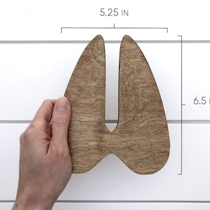 K&ouml;nnte beinhalten: Holzschnitt einer Hirschhufe, braun gebeizt, 13,3 cm breit und 16,5 cm hoch.