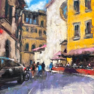 May include: An impressionistic painting of a European street scene. Buildings in shades of yellow, brown, and white line the street. People are walking on a purple-hued road. A black car is parked on the left. The sky is blue with white clouds.