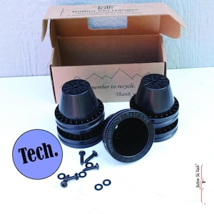 May include: Four black plastic ski rack mounts with a set of screws and washers. The mounts are stacked on top of each other and have a circular design. The text "Button Ski Rack.com" is printed on the side of one of the mounts. The mounts are in a cardboard box with the text "Tall Button Ski Hanger" printed on the top.