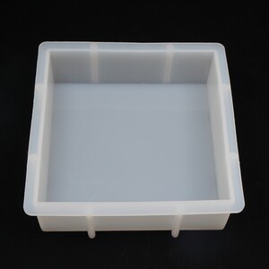 Pode incluir: Uma forma de silicone branca para fazer objetos de forma quadrada. A forma tem um acabamento liso e brilhante e &eacute; feita de silicone flex&iacute;vel.