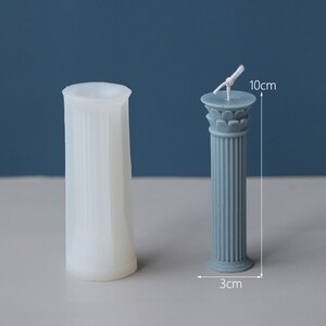 May include: A white silicone mold for making pillar candles shaped like a Roman column. The mold is 10 inches tall and 3 inches wide.