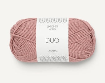 May include: A ball of pink yarn with a white label that reads "SADNES GARN DUO DEN NORSKE GARNFABRIKKEN SIDEN 1980"