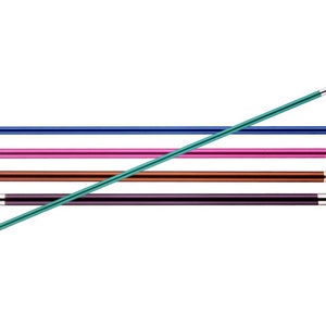 Könnte beinhalten: Eine Sammlung farbiger Stricknadeln in Blau, Pink, Braun und Lila mit silbernen Spitzen. Eine einzelne grüne Zopfnadel kreuzt die anderen. Die Nadeln sind horizontal vor einem weißen Hintergrund angeordnet.