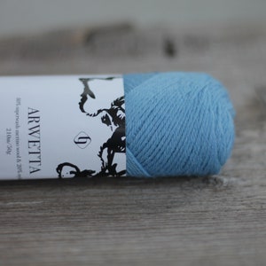 May include: A skein of light blue yarn labeled "ARWETTA" with the text "87% superwash merino wool & 20% 210m/50g filcolana OBSESSED WITH QUALITY YARN SINCE"