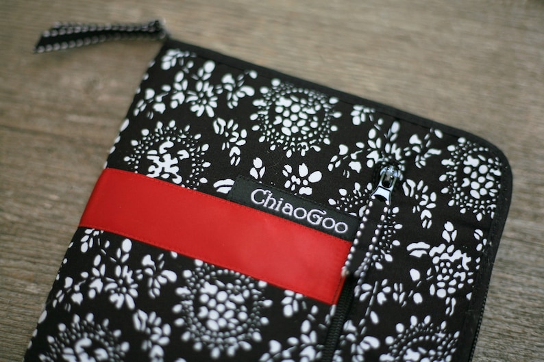 May include: Black and white patterned zippered pouch with a red fabric strip and the text "ChiaoGoo" on a black label.