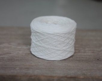 May include: A white ball of yarn, wound into a neat coil, ready for knitting or crocheting.