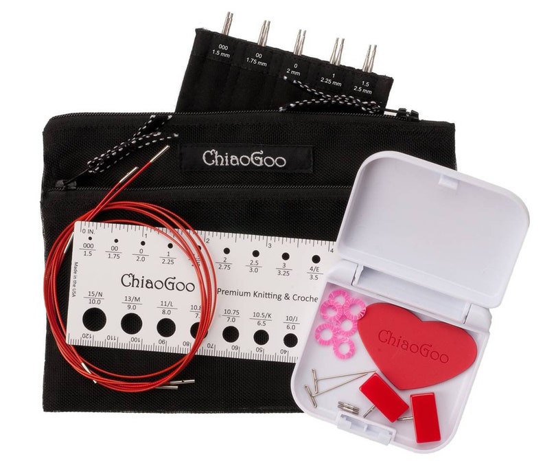 May include: A set of ChiaoGoo knitting needles and accessories in a black zippered pouch. The set includes a ruler, a red cable, and a small white case with a heart-shaped red pad, pink stitch markers, and needles.