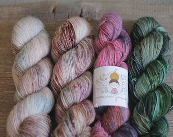 May include: Three skeins of hand-dyed yarn in shades of pink, green, and white with a label that reads "maruma yarns".