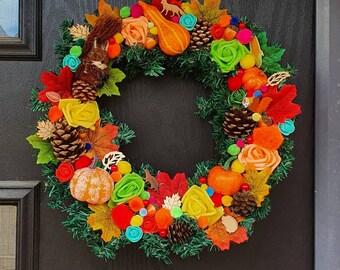 May include: A fall-themed wreath with a variety of autumn colors, including orange, red, yellow, and green. The wreath is decorated with pumpkins, leaves, pinecones, and other fall-themed accents.