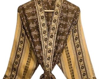 May include: A brown and tan patterned robe with a matching belt. The robe features a floral and geometric design, with a striped pattern on the sleeves. The robe is hanging on a wooden hanger.