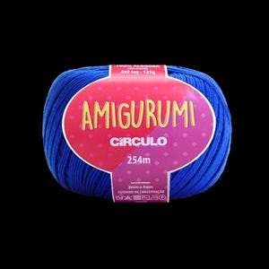 May include: A ball of blue Amigurumi yarn with a red and purple label. The label reads "AMIGURUMI CÍRCULO" and includes information about the yarn's length and care instructions. The yarn is 100% cotton.