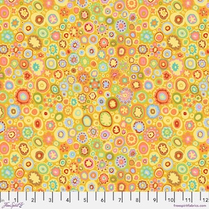 May include: A vibrant fabric with a repeating pattern of colorful, abstract floral shapes in shades of yellow, orange, pink, blue, and green. The design includes various sizes of circular and oval shapes. The fabric has a yellow background and a ruler with inches.