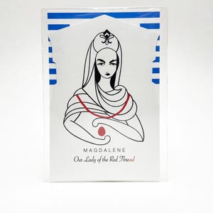 May include: A rectangular card featuring a black and white line drawing of a figure wearing a head covering and a red thread draped around the shoulders, holding a red egg. The text reads MAGDALENE Our Lady of the Red Thread. Blue stripes appear.
