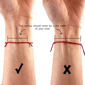 May include: A thin red string bracelet tied around a wrist with a diagram showing the correct overlap length. The text reads: The overlap should never be &ge; the width of your wrist. A checkmark indicates the correct fit and an X indicates the incorrect fit.