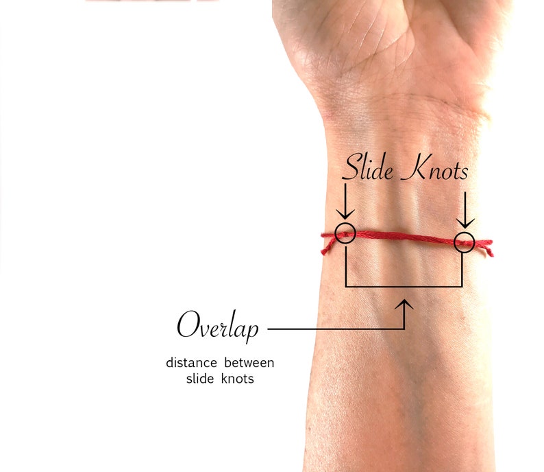 May include: A thin red string bracelet featuring two adjustable slide knots. The image includes text labels pointing to the slide knots and the overlap section, with the text 'Slide Knots', 'Overlap', and 'distance between slide knots' visible.