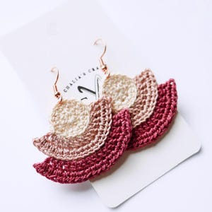 May include: Handmade crochet earrings in cream, tan, and burgundy. The earrings have a layered fan design with gold-coloured ear wires. The earrings are displayed on a white card with the text "CHALIA'S CRAFT".