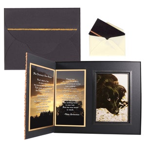 May include: A black framed photo memorial with a poem about loss and a photo of a black dog. The poem reads "Don't think of her as gone away, her journey has just begun. Life holds many fears, the Earth is only one. But think of her as resting from the sorrows and the tears, the worries and the fears, in a place of warmth and comfort, where days are filled with light and endless love." The poem is signed "Ellen Brenneman".