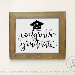 May include: A framed print with a black and white design of a graduation cap and the text "congrats graduate".