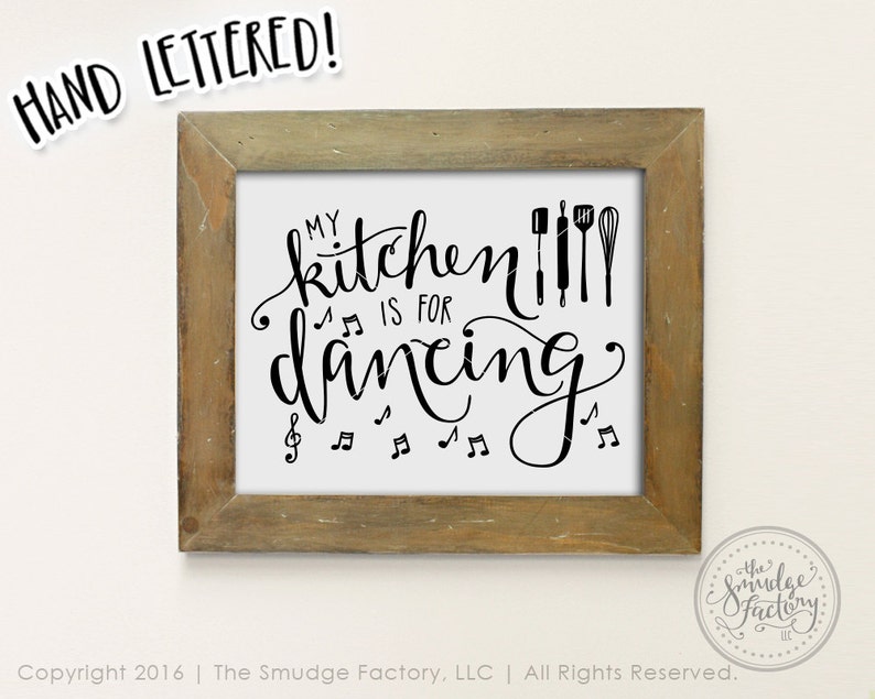 May include: A framed print with the text "My kitchen is for dancing" in black cursive script. The text is surrounded by musical notes and kitchen utensils.