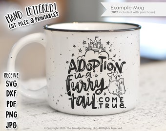 May include: White ceramic mug with a black design that says "Adoption is a furry tail come true." The design also includes a castle, stars, and two dogs.