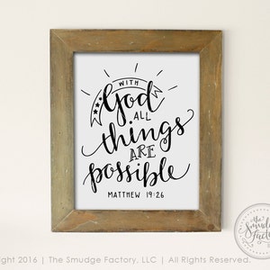 Op de afbeelding: Een ingelijst print met een inspirerend citaat in zwart en wit dat luidt "Met God is alles mogelijk" en de bijbelverwijzing "Matthe&uuml;s 19:26".