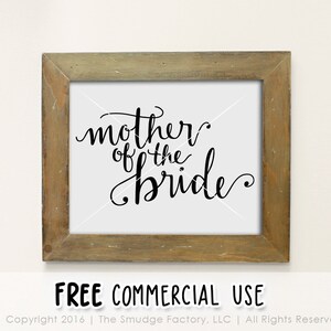 May include: A framed print with the text "mother of the bride" in black cursive script on a white background. The frame is a light brown wood.