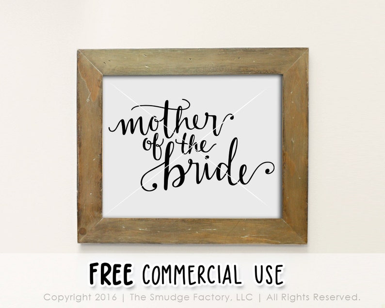 May include: A framed print with the text "mother of the bride" in black cursive script on a white background. The frame is a light brown wood.