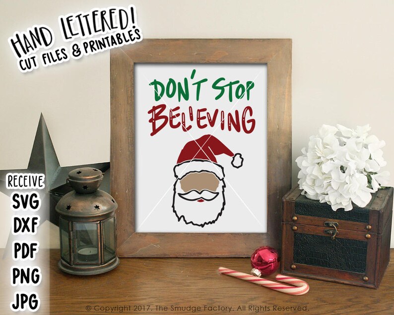 May include: A framed print with a white background and black text that reads "Don't Stop Believing". A cartoon image of a Santa Claus with a red hat and beard is below the text.
