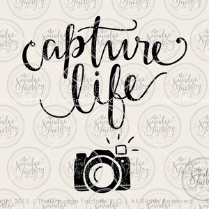 May include: Black and white graphic design with the text "capture life" and a silhouette of a camera with a flash.