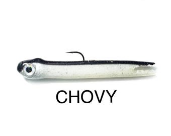 May include: A fishing lure shaped like a small fish with a black back, a white belly, and a silver head featuring a prominent eye. A single black metal hook protrudes from the top. The word CHOVY is printed in black capital letters below the lure.