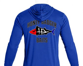 May include: A royal blue long-sleeve hooded shirt featuring a graphic on the back. The design includes the text HONEY BADGER BAITS in black with white outlines, surrounding a stylized fish with a red head and a blue tail fin.
