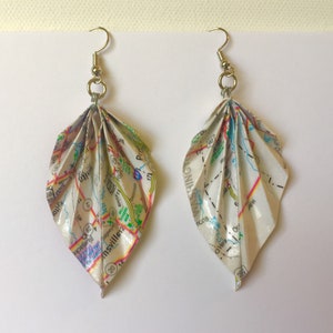May include: A pair of leaf-shaped earrings made from folded map paper. The earrings have silver-colored hooks and are detailed with roads, towns, and other map features. The paper is a mix of white, green, yellow, and pink.