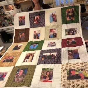 May include: A handmade quilt featuring a patchwork design with various fabric patterns and framed photographs. The quilt showcases a collection of personal photos, creating a unique and sentimental keepsake.