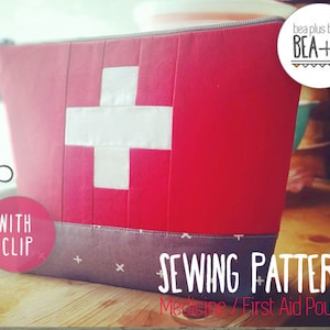 Puede incluir: Patrón de costura para una bolsa de medicina o primeros auxilios roja y blanca con un diseño de cruz suiza. El patrón se llama "BEA+R" e incluye instrucciones para un clip.