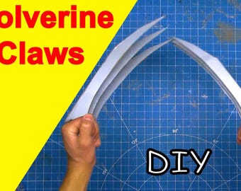 Op de afbeelding: DIY Wolverine-klauwen gemaakt van papier. De klauwen zijn zilverkleurig en worden vastgehouden door de handen van een persoon. De achtergrond is een blauw raster.