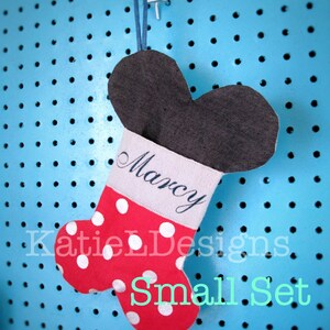 May include: Red and white polka dot stocking with a gray Mickey Mouse ear top and a white cuff with the name "Marcy" embroidered on it. The stocking is hanging on a blue pegboard with the text "Katie L Designs Small Set" below it.
