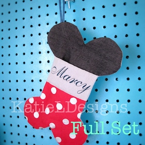 May include: A red and white polka dot Christmas stocking with a gray top and the name "Marcy" embroidered on the cuff. The stocking is hanging against a blue pegboard. The words "Full Set" are at the bottom.