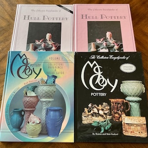 May include: Four books on pottery. Two books have pink covers with the title "The Collectors Encyclopedia of Hull Pottery". The other two books are titled "McCoy Pottery", one with a blue cover and the other with a black cover.