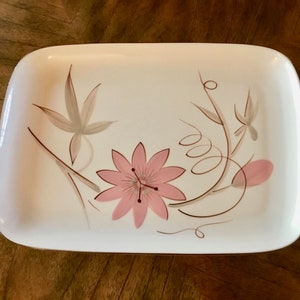 May include: A white rectangular serving platter with a gold rim features a floral design with pink and brown flowers and leaves.