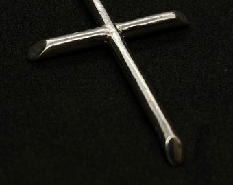 May include: A silver cross pendant with a simple design. The cross is made from a single piece of metal and has a smooth, polished finish.