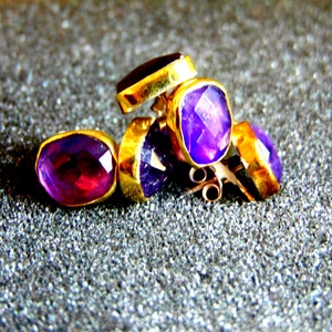 Peut inclure: Un ensemble de quatre boucles d'oreilles en am&eacute;thyste avec des montures en or. Les boucles d'oreilles sont facett&eacute;es et ont une teinte violette.