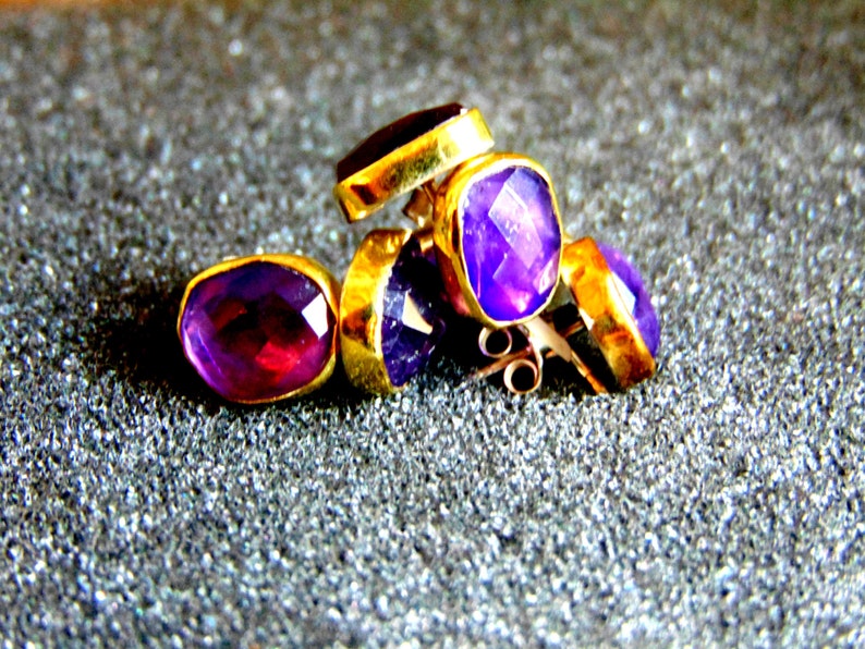 Peut inclure: Un ensemble de quatre boucles d'oreilles en am&eacute;thyste avec des montures en or. Les boucles d'oreilles sont facett&eacute;es et ont une teinte violette.