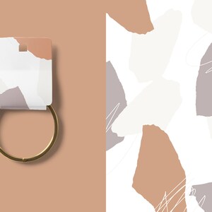May include: A gold metal bangle bracelet with a white tag featuring a torn paper design with brown, white, and gray colors.