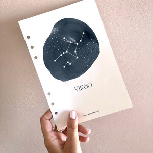 May include: A white card with a blue watercolor circle featuring the Virgo constellation. The text "VIRGO" is printed in black below the circle. The text "YOUANDIGRAPHICS" is printed in black at the bottom of the card.