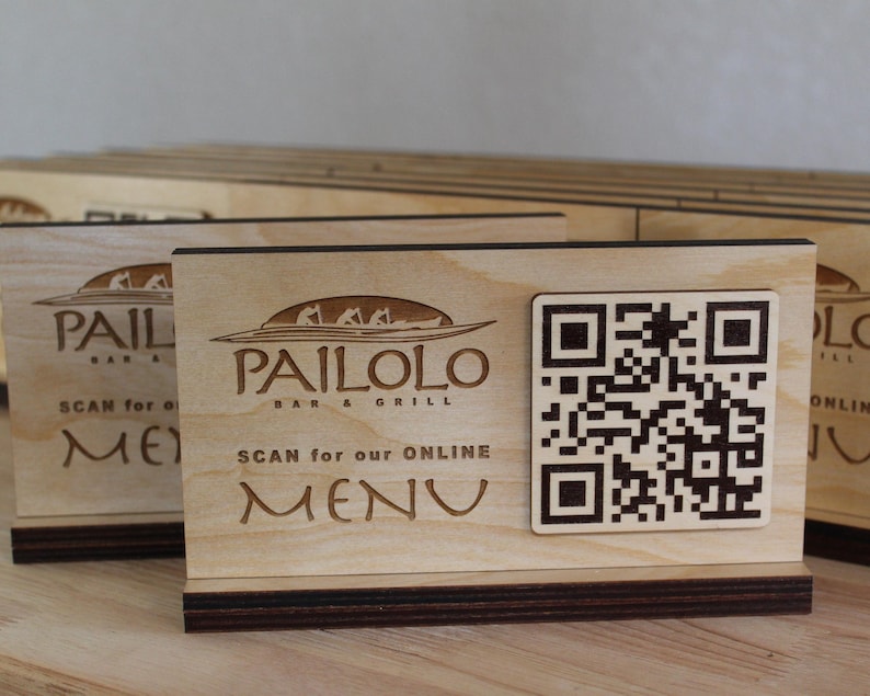 K&ouml;nnte beinhalten: Ein Schild aus Holz mit dem Text "Pailolo Bar & Grill" und einem QR-Code mit der Aufschrift "Scan for our online menu".