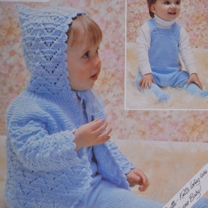 May include: A light blue knitted baby outfit with a matching hooded jacket. The jacket features a delicate lace pattern and the outfit has a simple design. "Soft & Gentle - Knits loving care around your Baby!" is written on the bottom of the image.
