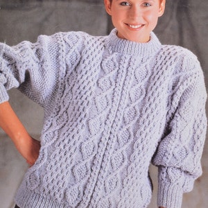 May include: A light purple cable knit sweater with a round neckline. The sweater has a textured pattern of woven cables.